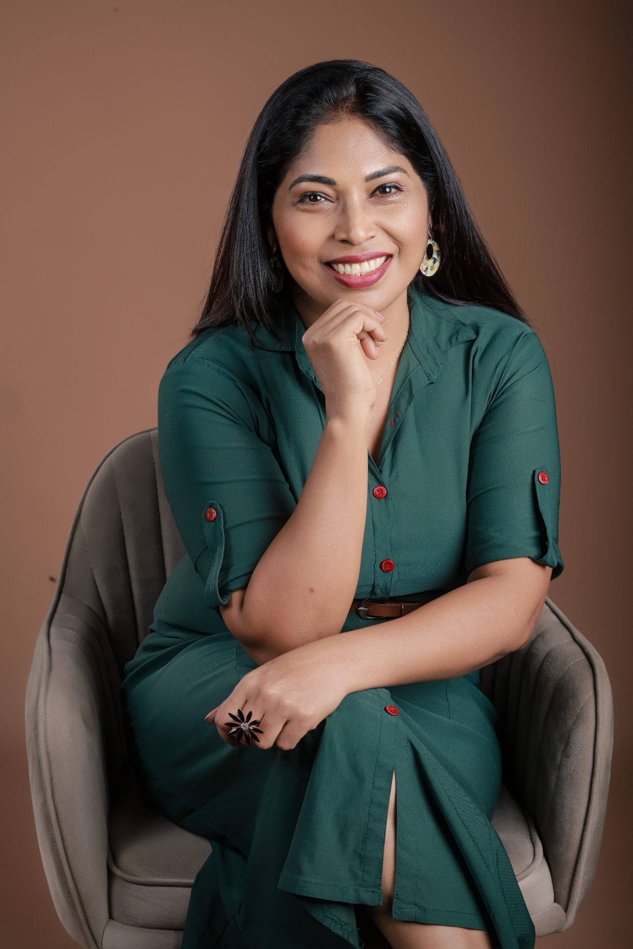 Dr. Indu Gangadhar, host of Kutty Podcast, smiling warmly in a green dress